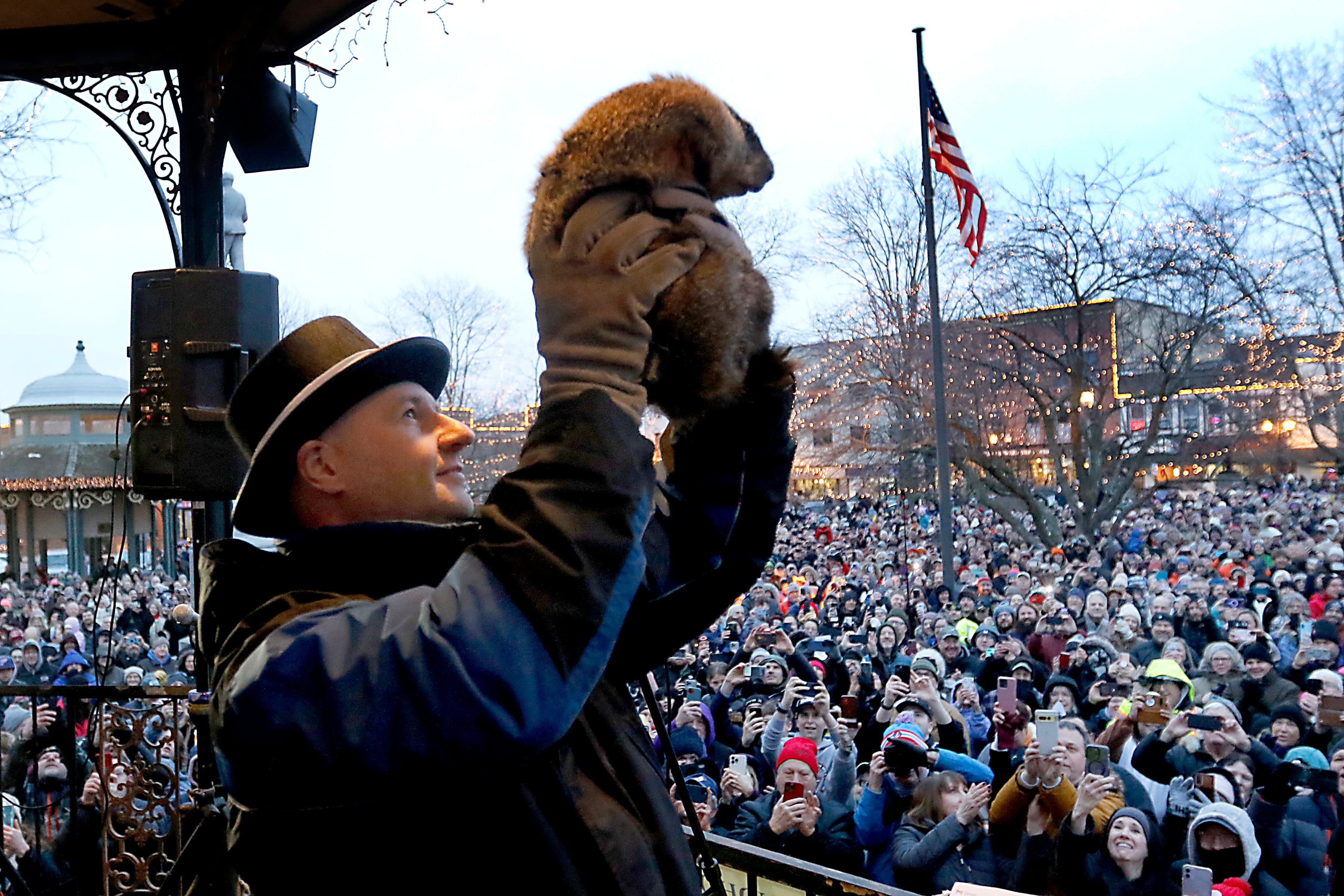 Woodstock Willie is held by handler Mark Szafran as Willie looks to see if he can see his shadow Friday, Feb. 2, 2024, during the annual Groundhog Day Prognostication on the Woodstock Square.