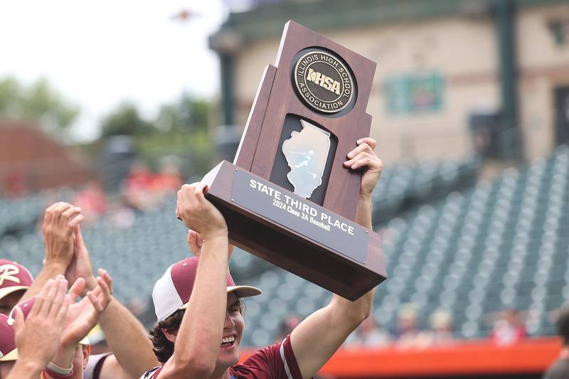 Morris’ A.J. Zweeres holds up the 3rd place trophy after their 1-0 8 inning win against Highland in the IHSA Class 3A 3rd place game on Saturday June 8, 2024 Duly Health and Care Field in Joliet.