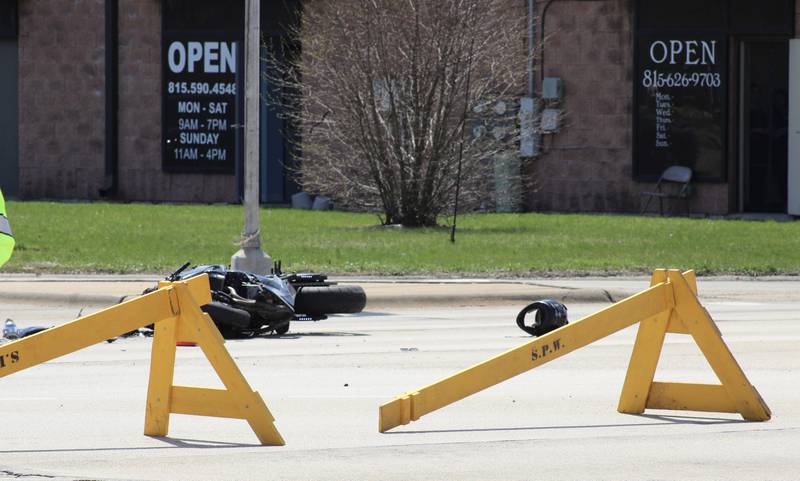 A motorcycle and a helmet lay on the pavement beyond barricades protecting the crash scene Thursday at the intersection of East Lynn Boulevard and Lincolnway-Illinois Route 2 in Sterling.