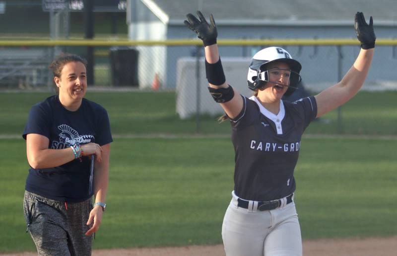 Cary-Grove’s Maddie Crick connected for a game-ending home run against Burlington Central in varsity softball at Cary Monday. Head Coach Cara Neff, left, enjoys the moment.