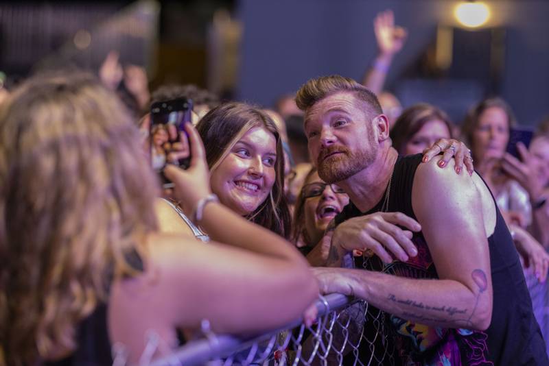 Marshal Dutton, lead vocalist of Hinder, poses for photos with fans during their performance at Streatorfest on August 1, 2024.