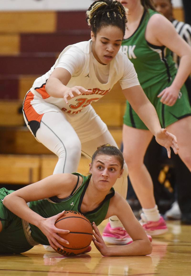 Yorks’ Stella Kohl goes to the floor for a loose ball in front of St. Charles East’s Corinne Reed during the semifinal of the Montini girls basketball tournament Thursday December 28, 2023 in Lombard.