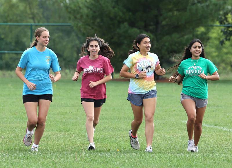 Korima Gonzalez (second from right) warms up with her teammates during practice Monday, Aug. 14, 2023, at DeKalb High School.