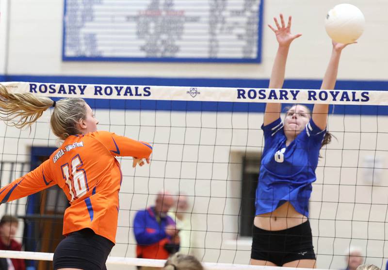 Rosary's Sarah Schmidt tries to block the spike of Genoa-Kingston's Alayna Pierce during their Regional semifinal match Tuesday, Oct. 25, 2022, at Rosary High School in Aurora