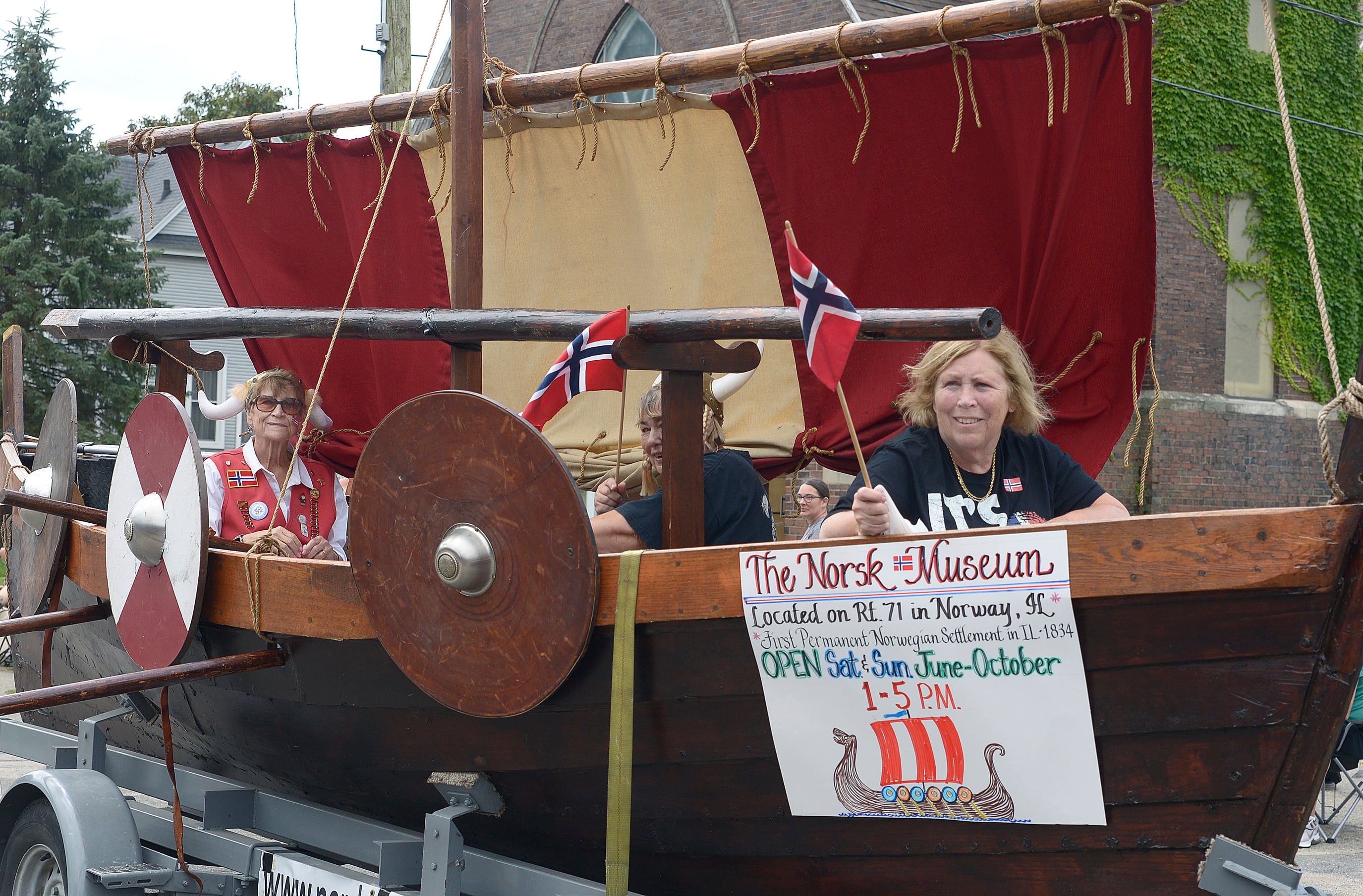 Some members of the Norsk Museum from Norway ride along in a Viking ship during the Community Fest Parade Sunday in Grand Ridge.