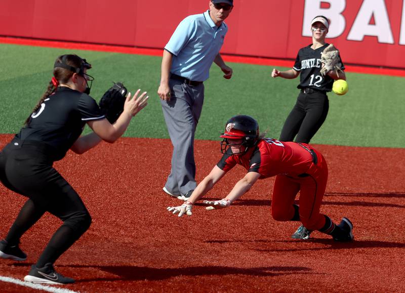 Huntley’s Christina Smith, left, fields the toss as Barrington’s Amelia Cline slides safely at third base in sectional final softball  action at Barrington Friday.