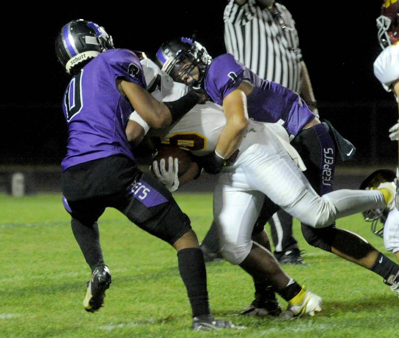 Plano defenders Andrew Cox (0) and Armando Martinez (1) tackle Westmont running back Darius Stevenson, Jr. during a varsity football game at Plano High School on Friday, Sept. 9, 2022.