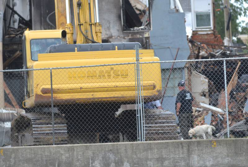 A search dog examines debris Tuesday, July 11, 2023, from a July 7 fire that destroyed an apartment building at 406 E. Third St. in Sterling.