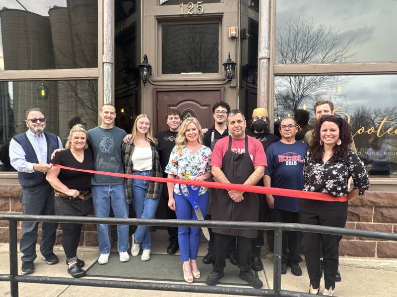 Members of the Minooka-Channahon Chamber of Commerce and the owners of Rooted cut the ribbon on the new business.