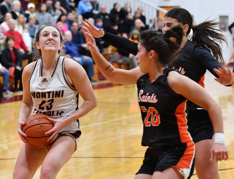 Montini's Shea Carver (23) looks to the basket as St. Charles East's Alexis Maridis (20) and Lexi DiOrio defend during the Montini Christmas Tournament championship game on Dec. 29, 2023 at Montini Catholic High School in Lombard.