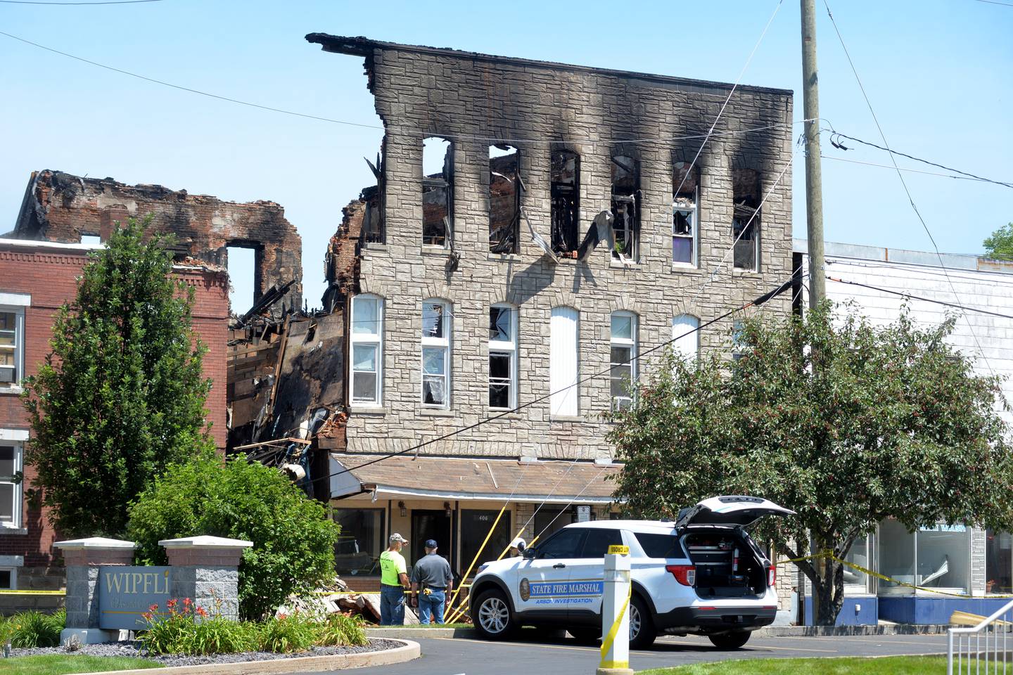 Two people examine building remains after an early morning fire at 406 E. Third St. in Sterling destroyed a three-story building July 7.