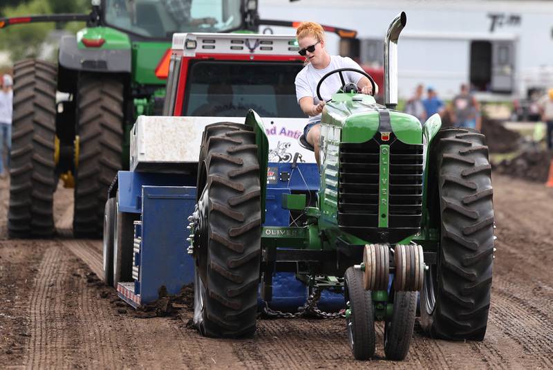 Cassie Mack, from Harvard, finishes her run in the 4500 farm stock division in the tractor pull Saturday, July 15, 2023, during the Waterman Lions Summerfest and Antique Tractor and Truck Show at Waterman Lions Club Park.