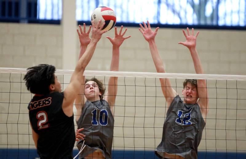 Geneva’s Kellen Prysmiki (left) and Ian Sofiak (right) block a shot from Wheaton Warrenville South’s Mergen Purevsuren during a game at Geneva on Tuesday, April 2, 2024.