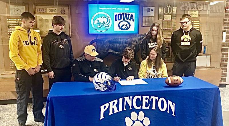 Princeton High School senior Teegan Davis (center) signs his National Letter of Intent to play football for the University of Iowa. He's pictured with his parents, Spencer and Annette; and his siblings (back, from left) Cael, Drake, Keighley and Wyatt.