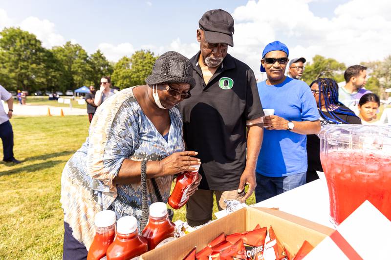 Minooka residents Christine and Ivory Webb fix up their hotdogs during Lockport Township Park District's Juneteenth Celebration at A.F. Hill Park on June 19, 2024.