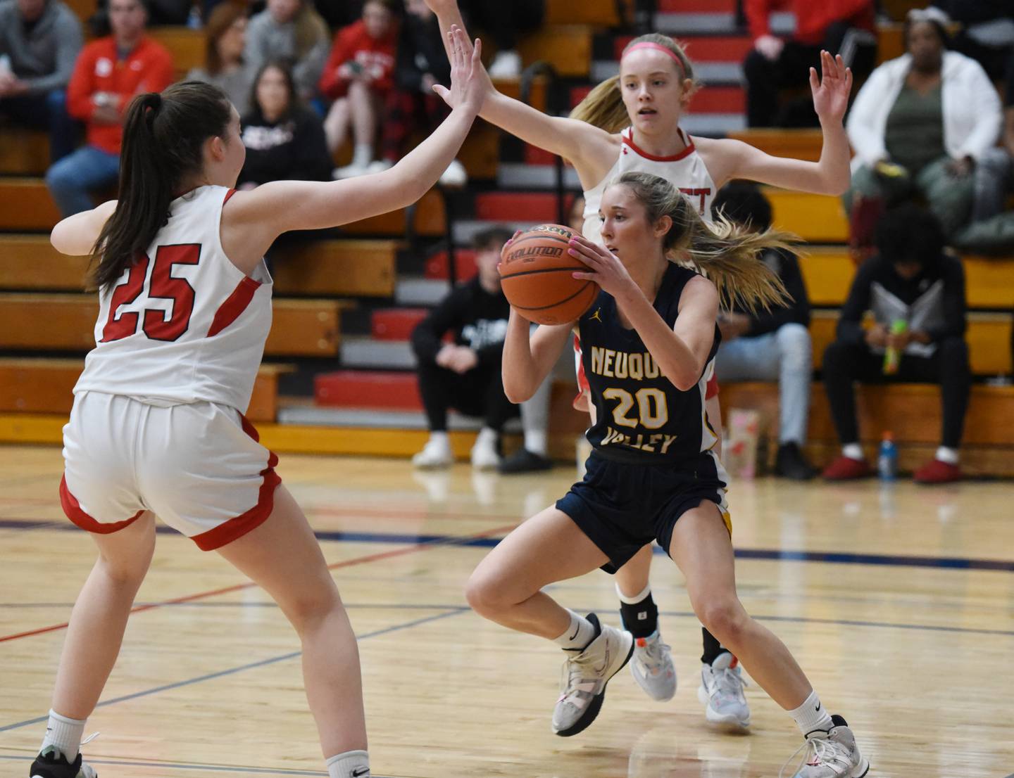 Neuqua Valley's Kylee Norkus (20) looks for room to operate around Benet's Samantha Trimmberger (25) and Bridget Rifenburg during Tuesday’s IHSA Class 4A regional semifinal girls basketball game in Aurora.