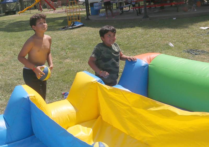 RJ Carter and Christopher Garcia take turns shooting baskets on a bounce house during the Juneteenth event on Wednesday June 19, 2024 at Kirby Park in Spring Valley.