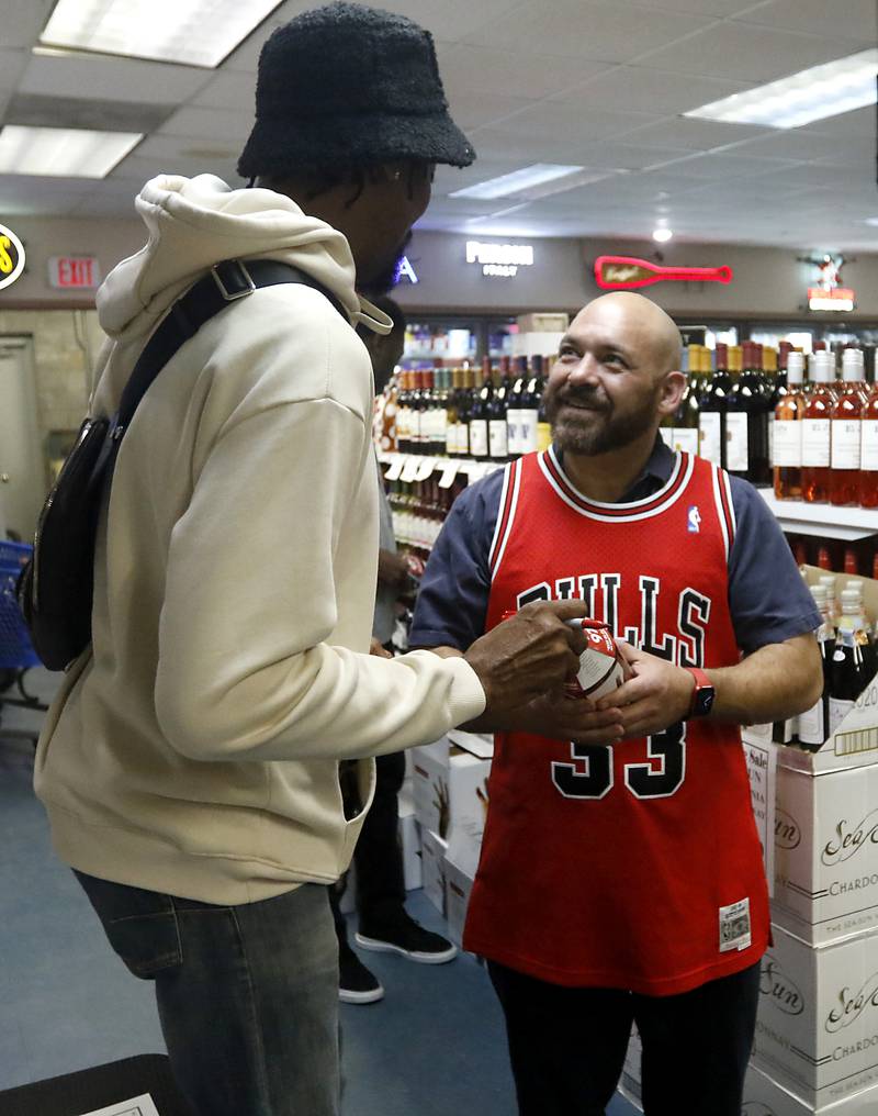 Robert Spencer talks to retired Chicago Bulls star Scottie Pippen after Pippen signed a bottle of his Digits bourbon Thursday, Feb. 9, 2023, at The International House of Wine and Cheese, at 11302 Route 12, in Richmond.