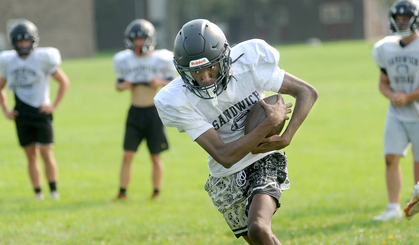 Running back Simeion Harris takes a pitch around the end during early summer football practice at Sandwich High School on Monday, July 17, 2023.