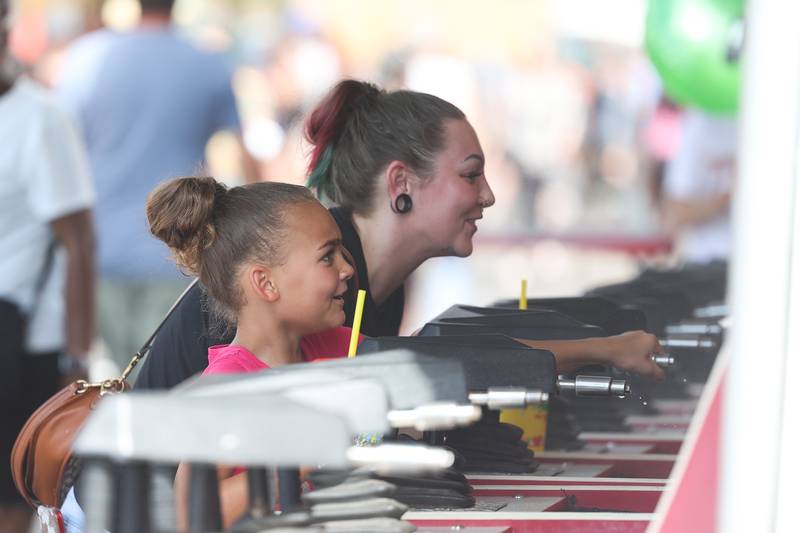 Snannon Baker, of Joliet, plays a water game with her daughter Promise, 9-years-old, at Plainfield Fest on Saturday June 29, 2024.