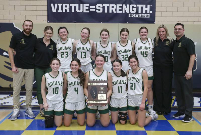Members of the St. Bede girls basketball team pose with the Class 1A Regional plaque after defeating Amboy on Friday, Feb. 16, 2024 at Marquette High School.