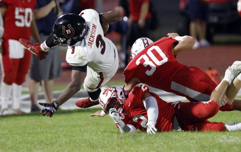 Barrington's Calvin Jackson (3) dives over South Elgin's Nico Barkho (2) and a teammate Friday, Aug. 30, 2024 in South Elgin.