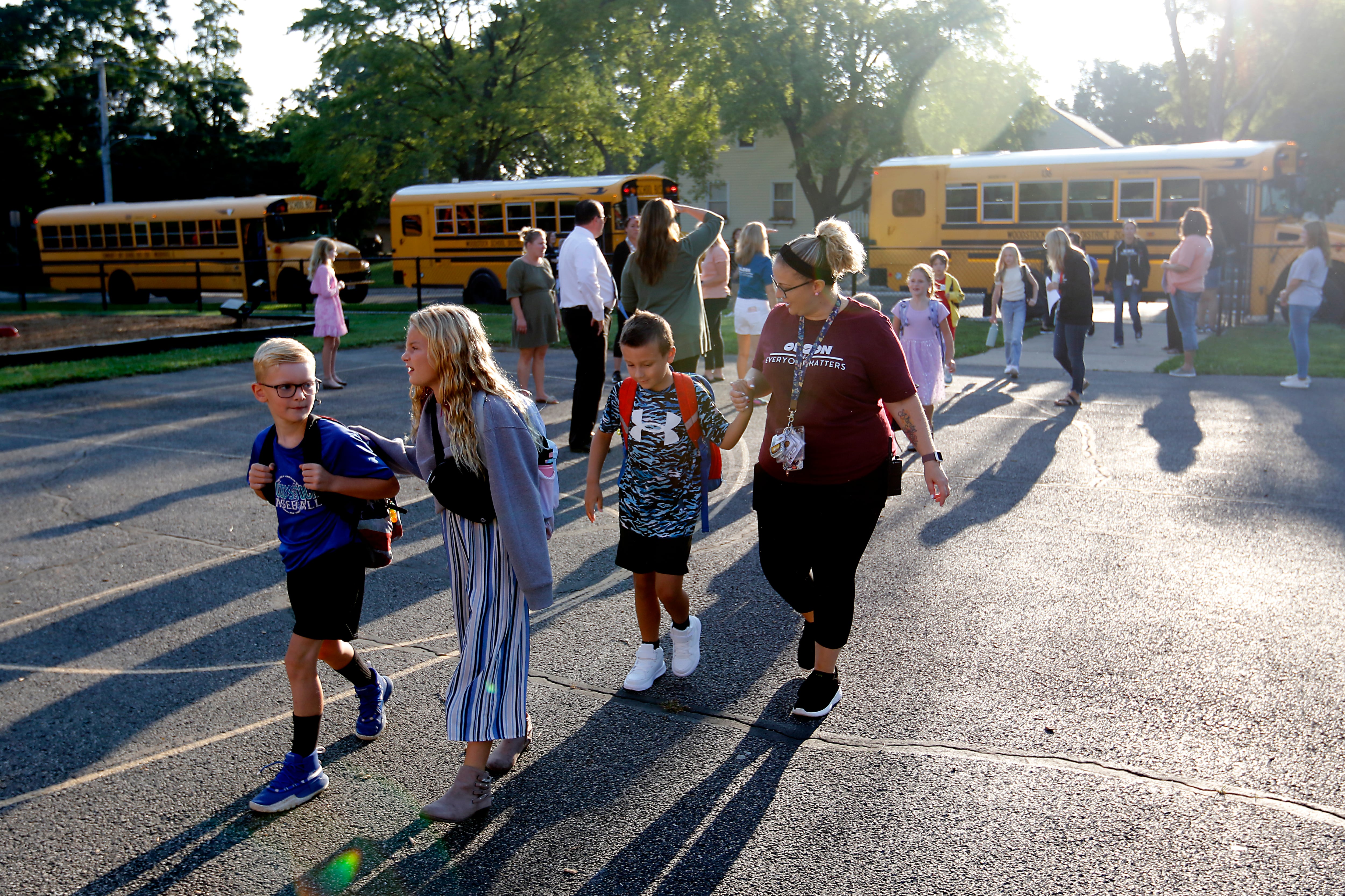 Students walk towards the school after getting off the school bus for the first day of school on Wednesday, Aug. 14, 2024, at Olson Elementary School in Woodstock.