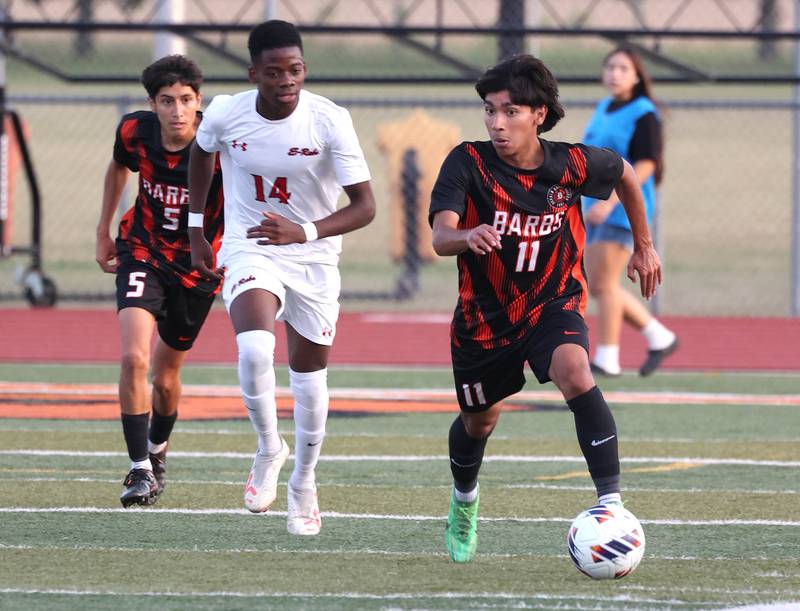 DeKalb's Edwinn Cortina pushes the ball ahead of Rockford East's Winazi Jules during their game Thursday, Sept. 12, 2024, at DeKalb High School.