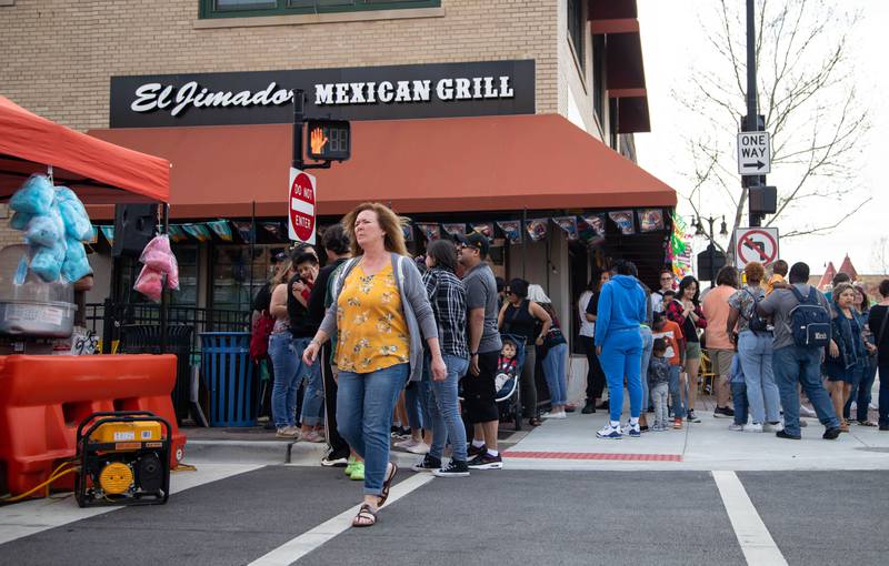 Attendees wait for drinks outside of El Jimador Mexican Grill during Dekalb’s first Cinco de Mayo celebration co-hosted by Willrett Flower Co. on 3rd street in Dekalb on Friday, May 5, 2023.
