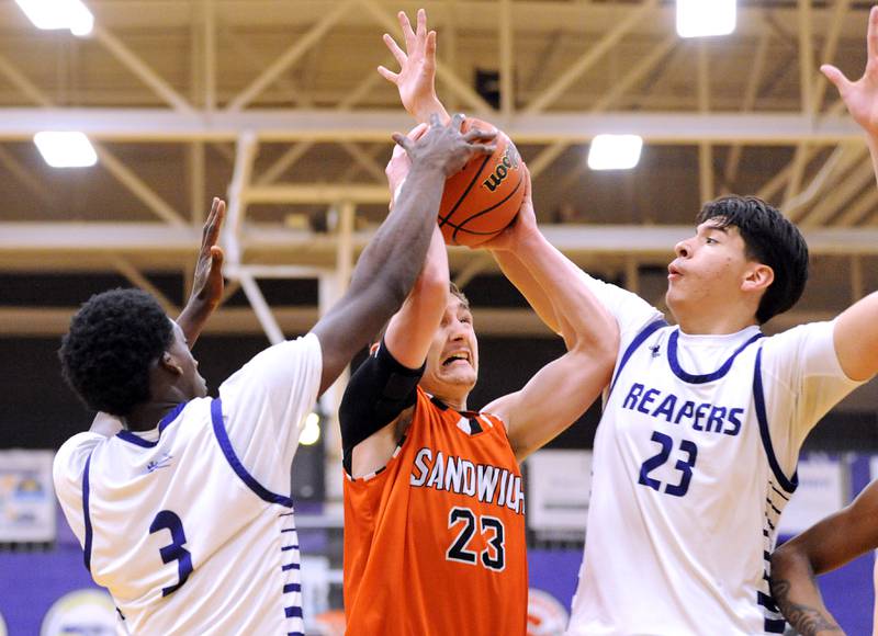 Sandwich's Chance Lange (23) runs into Plano defenders Christ Keleba (3) and Isaiah Martinez (23) during a varsity basketball game at Plano High School on Tuesday, Dec. 5, 2023.