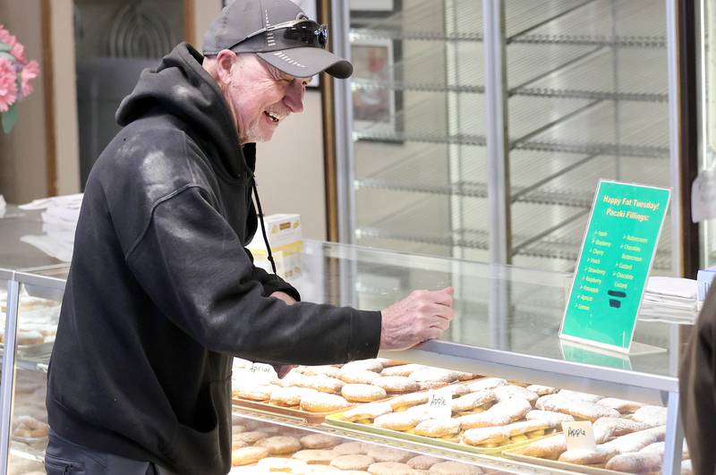 A customer laughs as he picks out his paczki Tuesday, Feb. 21, 2023, at Elleson's Bakery in Sycamore. Fat Tuesday has also become know as Paczki Day in some areas due to the tradition of enjoying the fried Polish dessert.