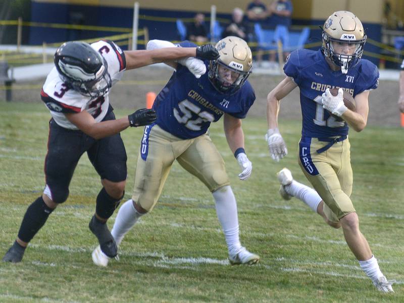 Marquette’s Payton Gutierrez runs to get by Aurora Christian’s Chris Fielding on a run in the 1st quarter Friday at Marquette.