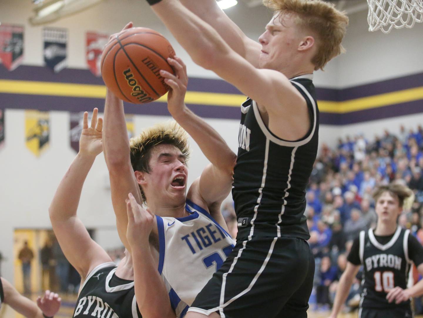 Princeton's Noah LaPorte is sandwiched between Byron players Jack Hiveley and Carson Buser on a drive to the hoop during the Class 2A sectional final Friday, March 1, 2024, at Mendota High School.