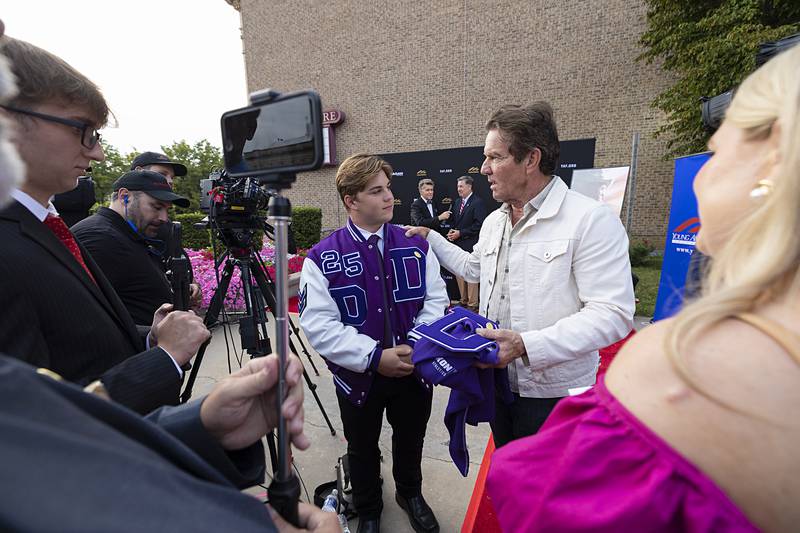 Dixon High School student Tyler Zepezauer presents actor Dennis Quaid with a varsity letter Thursday, Aug. 22, 2024, before the premier of “Reagan.” Zepezauer, along with Cooper Fox (left) and Jackson Barber are part of the broadcast club at DHS.