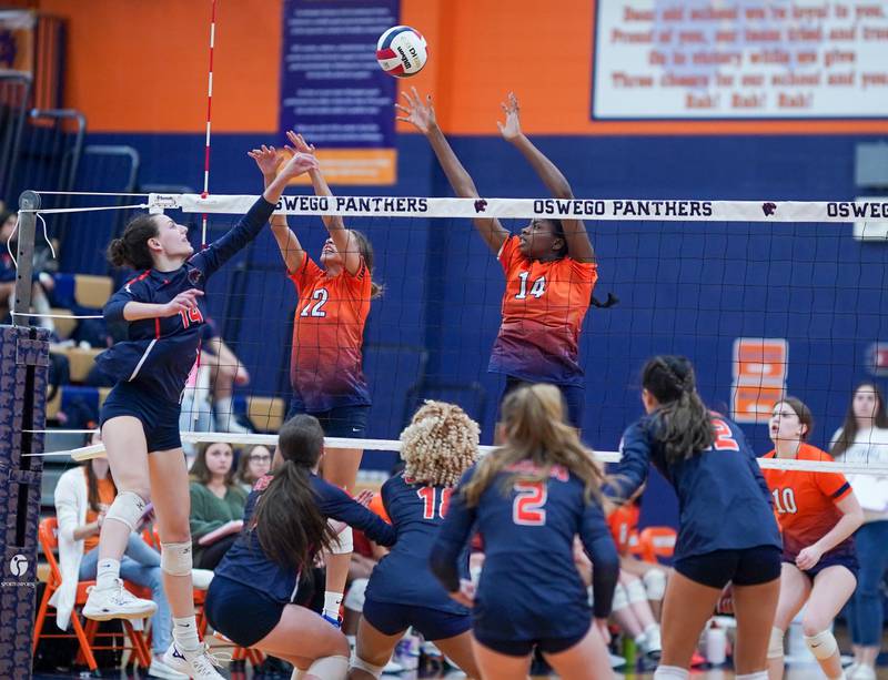 Romeoville's Taylor Cicero (12) and Romeoville's Demi Cole (14) defend the net against a kill attempt by Oswego’s Mia Jurkovic (14) during a volleyball game at Oswego High School on Tuesday, Oct. 17, 2023.