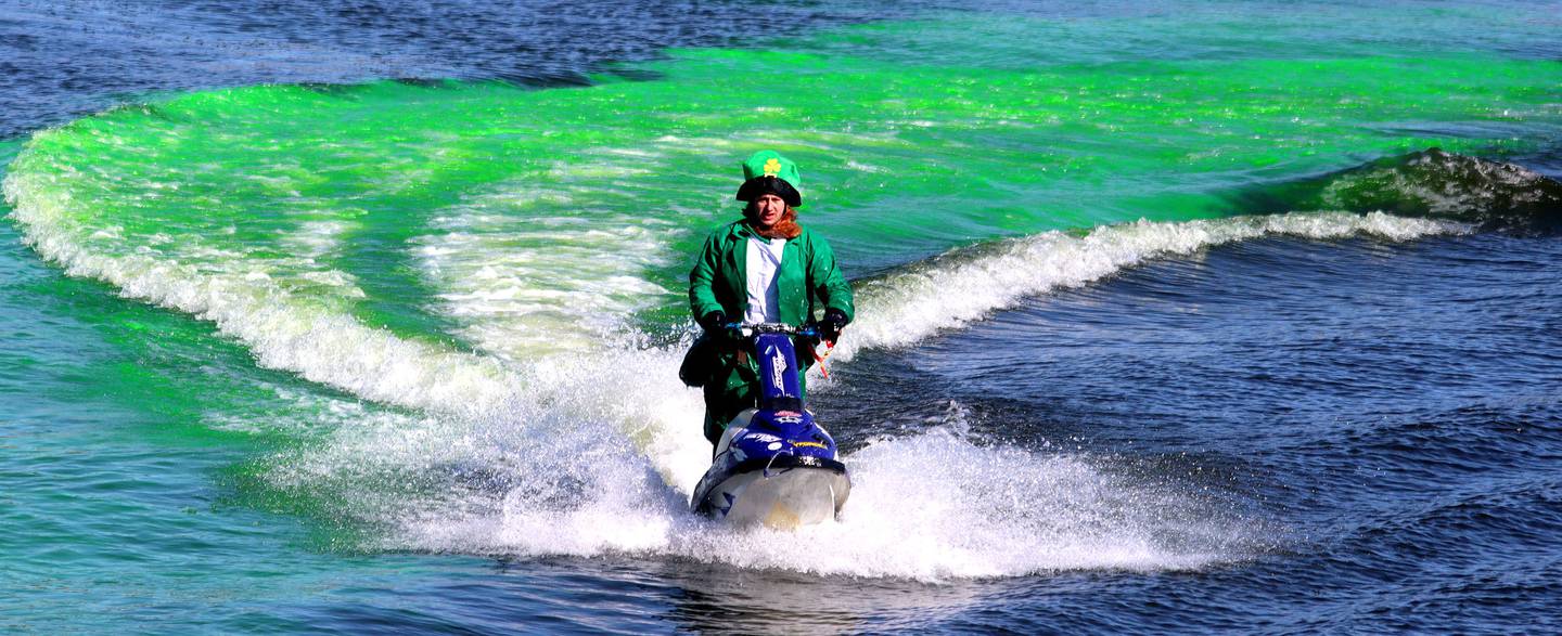 A jet skier clad dressed as a leprechaun stirs dye into the Fox River during the ShamROCKS the Fox festival in McHenry on Saturday, March 12, 2022.
