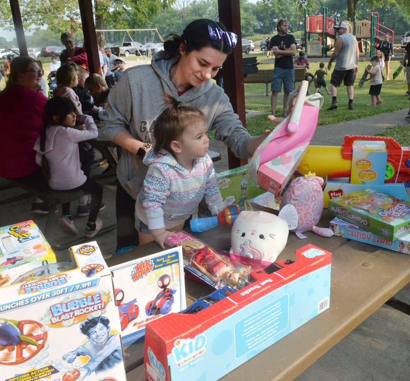 Halle BEntley, 2, of Lyndon, picks out a toy with the help of her mom, Breanna, at the 17th Dick Brown Fishing Derby for kids at Prophetstown State Park on Saturday. The event is run by the Prophetstown Police Department and prizes are donated by local businesses.