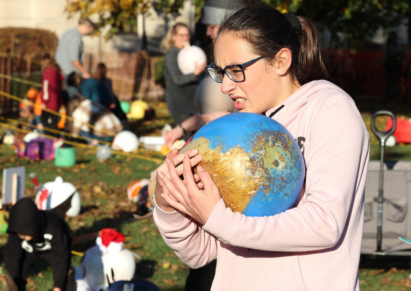 Bronwyn Butler, 12, from Sycamore totes her heavy pumpkin into the pumpkin display area Wednesday, Oct.26, 2022 on the DeKalb County Courthouse lawn during the first day of the Sycamore Pumpkin Festival.