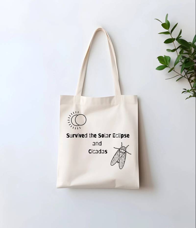A mockup of a cicada and solar eclipse tote bag on Tammy Maher of Cary's Etsy store.