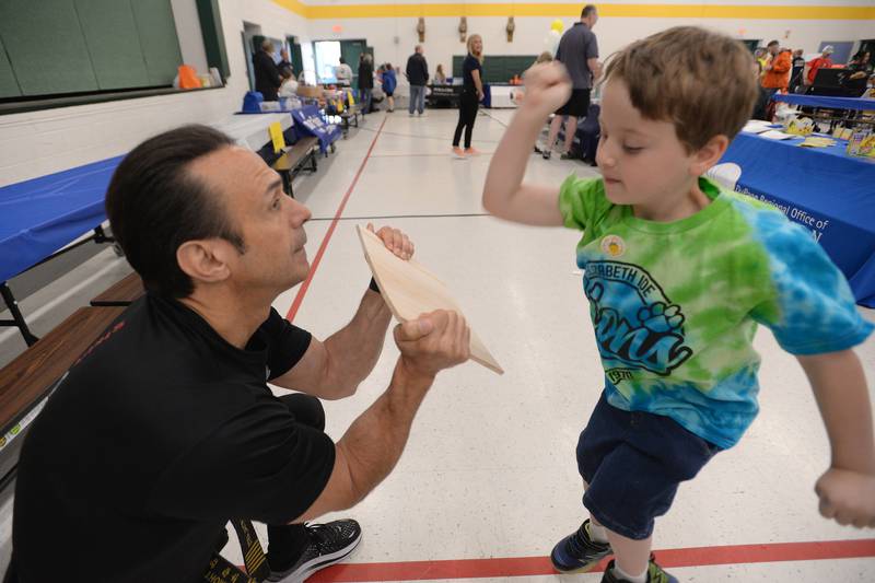 Lucas Esposito of Downers Grove is among the children who test their martial arts skills with the help of Strive Martial Arts employee Bill Thompson during the Child Safety Expo held at Lakeview Junior High in Downers Grove Saturday June 1, 2024.