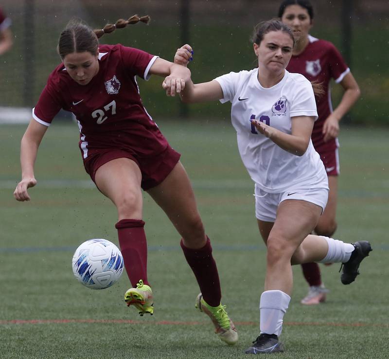 Prairie Ridge's Ava Gertz tries to control the ball as she battles with Hampshire's Adriana Hurley during a Fox Valley Conference soccer game on Tuesday, April 16, 2024, at the MAC Athletic Complex in Crystal Lake.