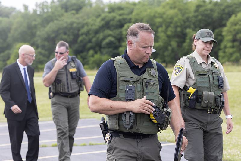 Followed by local law enforcement members, Ogle County Sheriff Brian VanVickle enters a news conference Wednesday, June 12, 2024, after three deputies were injured in a shootout in Lost Lake.