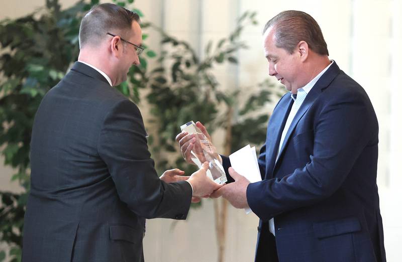 John Huddleston, director of Upstaging, Inc., accepts the Outstanding Business of the Year Award from Robert Heck, Sycamore Chamber of Commerce board president, during the chambers annual meeting Thursday, April 7, 2022, at St. Mary Memorial Hall in Sycamore.