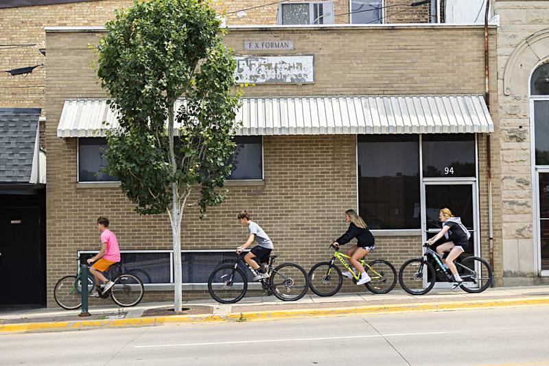 Bike riders pass an empty storefront at 94 S. Peoria Avenue in Dixon Friday, June 16, 2023. A businessman has designs to turn the place into an arcade.