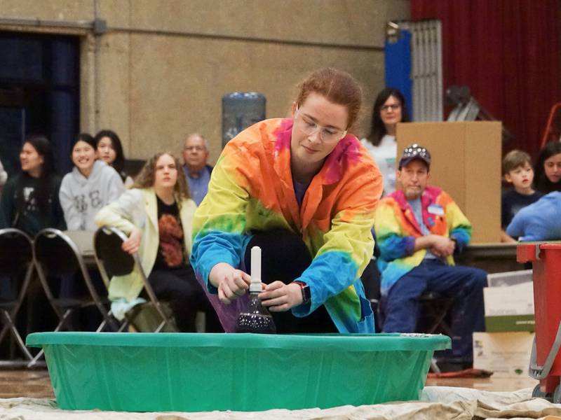 Jennifer Roesler demonstrates the explosion of carbonation when mixing soda and Mentos on Friday, April 19, 2024, at Illinois Valley Community College in Oglesby.