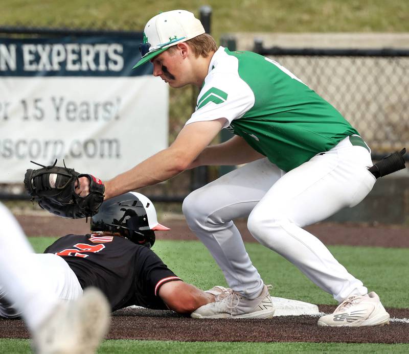 Providence Catholic's Nate O'Donnell applies a late tag as Edwardsville's Kolten Wright slides in safely on a pickoff attempt at first during their Class 4A state semifinal game Friday, June 7, 2024, at Duly Health and Care Field in Joliet.