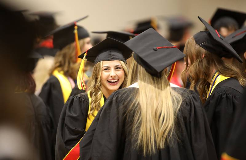 Batavia High School graduate Isabelle Taylor laughs with friends before the school’s 2024 commencement ceremony at Northern Illinois University in DeKalb on Wednesday, May 22, 2024.