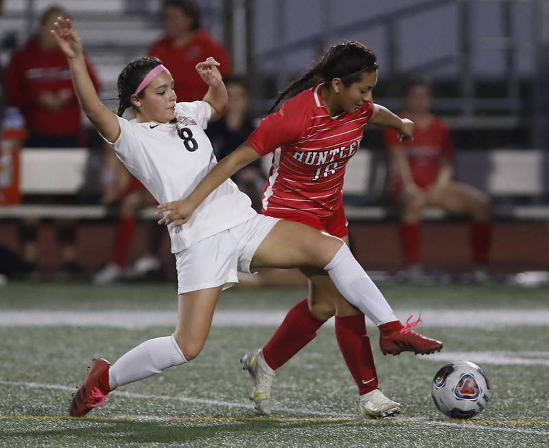 McHenry's Elena Carlos kicks the ball away from Huntley’s Karen Reyes-Villanueva during a Fox Valley Conference soccer match Thursday, April 13, 2023, at Huntley High School.