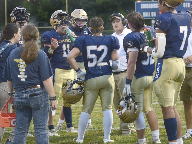 Marquette Head Coach Tom Jobst talks with the team during a time out during the Crusaders home opener Friday against Aurora Christian.