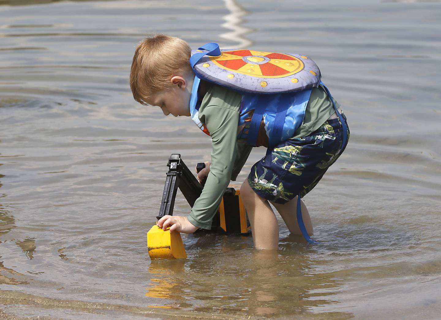 Mason Stolz, 3, plays with his toy excavator in the water on Friday, June 21, 2024, at Crystal Lake's Main Beach.